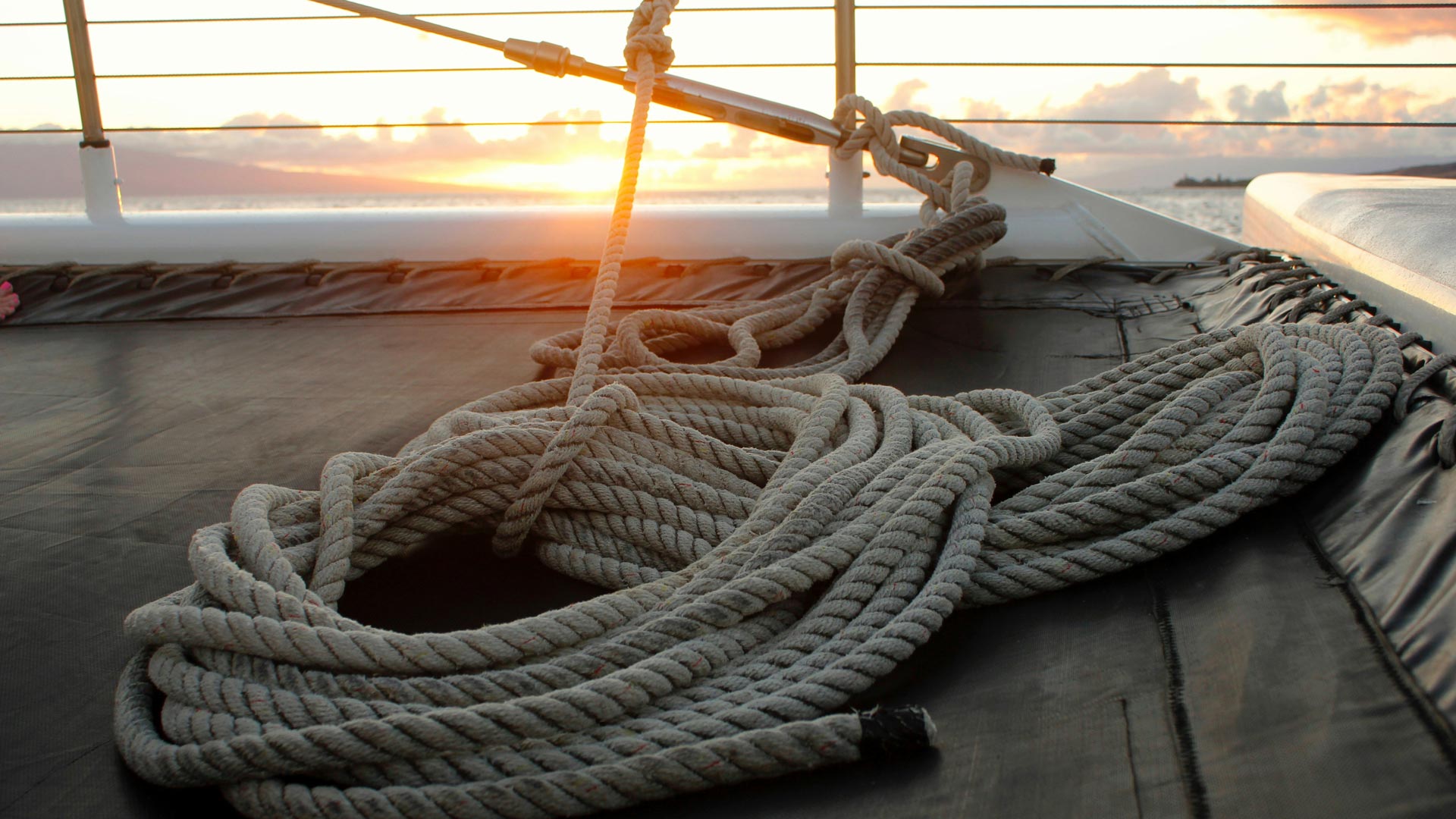 Cordage marin enroulé sur le pont d’un bateau au coucher du soleil - nœuds marins essentiels pour la navigation en mer