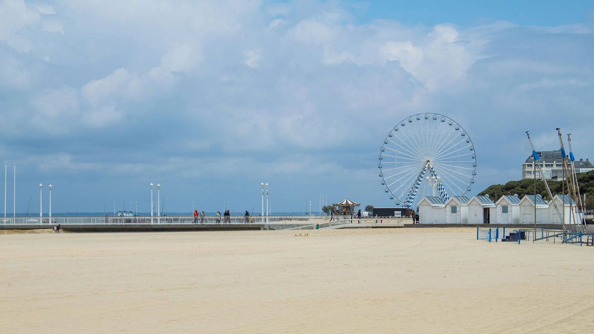 Vue sur la plage Thiers d’Arcachon avec la grande roue, les cabanes blanches, la jetée Thiers et le Bassin d’Arcachon à l’horizon