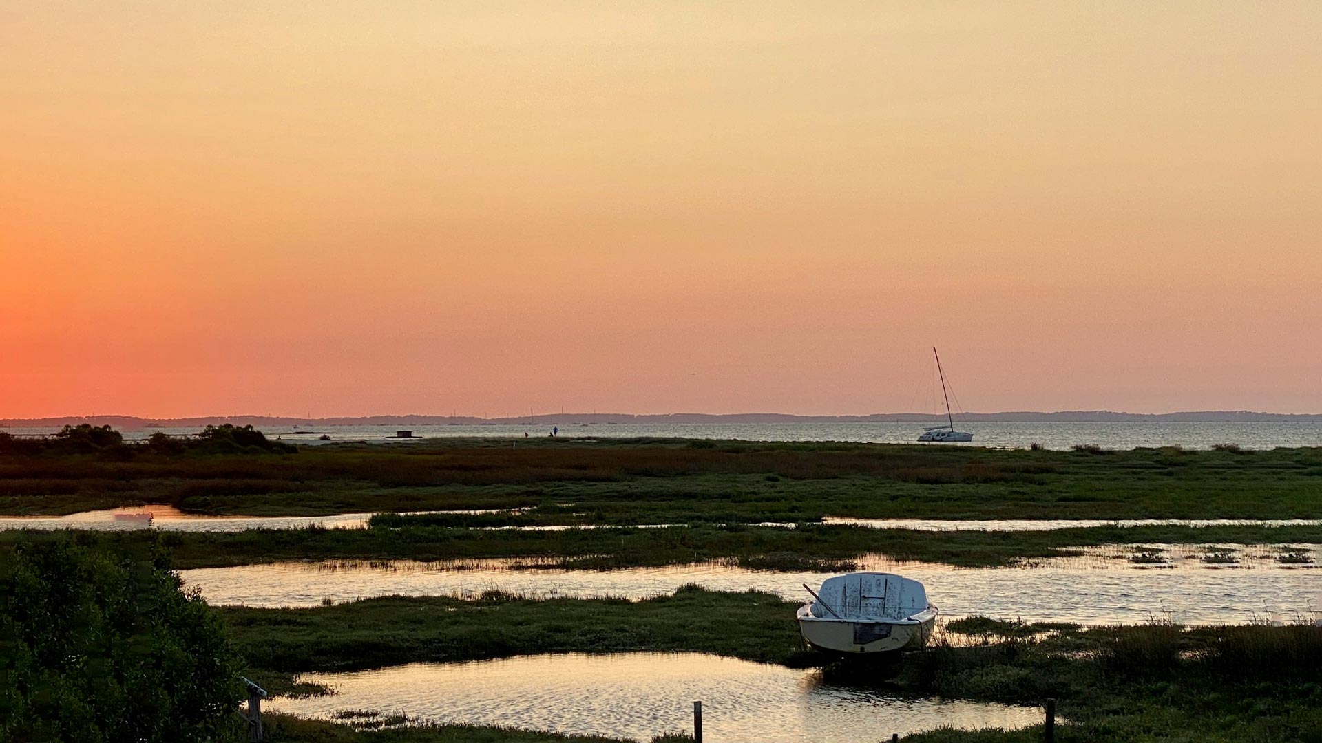 Bateau échoué au coucher du soleil sur le Bassin d'Arcachon, paysage naturel de marais et vue sur l'océan Atlantique